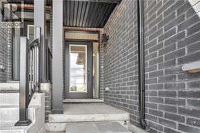 Paris townhouse for rent - A modern house entrance with a glass door and a brick wall.