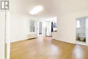 Toronto (Yonge-Eglinton) apartment for rent - A spacious room with wooden floors and white walls.
