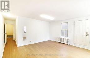 Toronto (Yonge-Eglinton) apartment for rent - A white room with a wooden floor and a door on the right side.