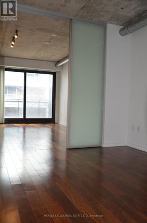 Toronto (Moss Park) condo for rent - A room with wood floors and a large window.