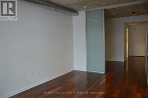 Toronto (Moss Park) condo for rent - A room with wooden floors and white walls.