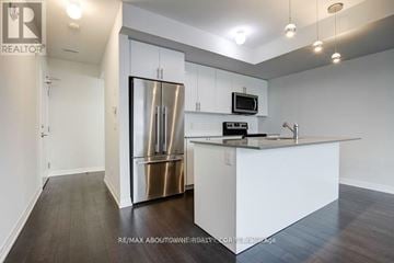 Milton (De Dempsey) townhouse for rent - A modern kitchen with white cabinets and a stainless steel refrigerator.