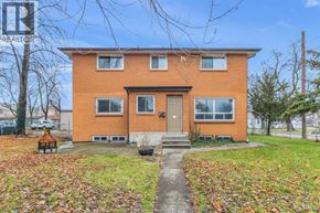 Windsor duplex for rent - A red brick house with a front yard covered in fallen leaves.