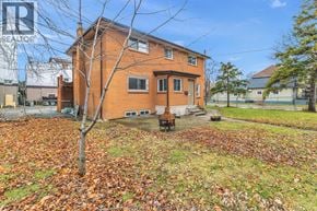 Windsor duplex for rent - A house with a tree in front of it surrounded by fallen leaves.