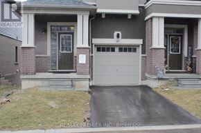 Brantford townhouse for rent - A house with a garage and a sign that says RE/MAX Premier INC., Brokerage.