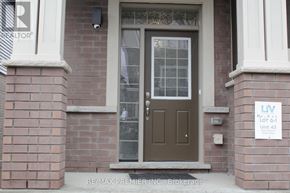 Brantford townhouse for rent - A brown door with a glass window and a sign on the wall.