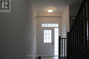 Brantford townhouse for rent - A hallway with a white door and a light on the ceiling.
