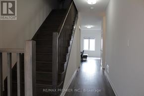 Brantford townhouse for rent - A hallway with a staircase and a window.