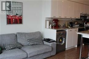 Toronto (Bayview Village) condo for rent - A grey couch with two pillows sits in a kitchen.