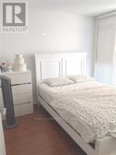 Toronto (Bayview Village) condo for rent - A bedroom with a bed, nightstand and a dresser.