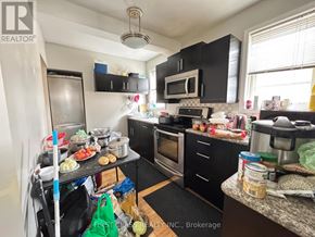 Toronto (Wexford-Maryvale) apartment for rent - A kitchen with black cabinets and a wooden table.