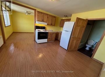 French River multi-family for rent - A kitchen with wooden floors and yellow walls.