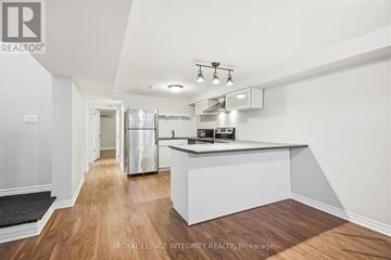 Ottawa apartment for rent - A modern kitchen with white cabinets and a wooden floor.
