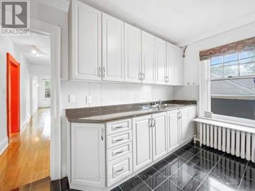 Toronto (Annex) apartment for rent - A kitchen with white cabinets and a black countertop.