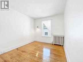 Toronto (Annex) apartment for rent - A room with wooden flooring and a window with white curtains.