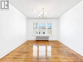 Toronto (Annex) apartment for rent - A room with a wooden floor and a window with a radiator beneath it.