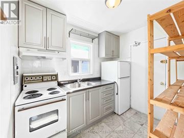 Toronto (Woodbine Corridor) apartment for rent - A kitchen with white appliances and wooden cabinets.
