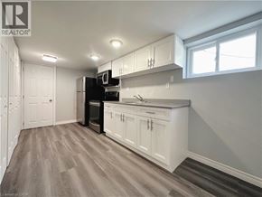 Kitchener apartment for rent - A kitchen with white cabinets and a wooden floor.