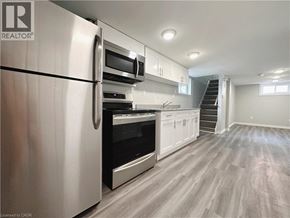 Kitchener apartment for rent - A modern kitchen with a stainless steel refrigerator and wooden flooring.