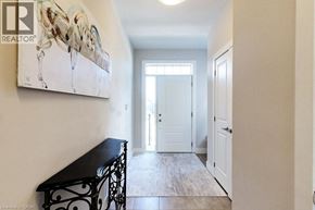 Grey apartment for rent - A hallway with a black bench and a painting of wine glasses on the wall.