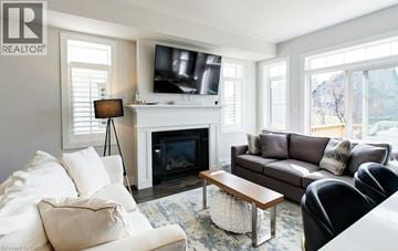 Grey apartment for rent - A living room with a fireplace and a television on the wall.