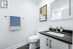 Toronto (Moss Park) multi-family for rent - A bathroom with a toilet, sink, and a mirror.