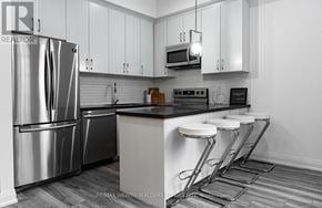 Toronto (Moss Park) multi-family for rent - A modern kitchen with a stainless steel refrigerator and white cabinets.