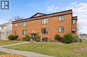 Windsor apartment for rent - A red brick building with a black fence in front.