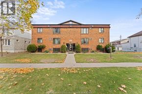 Windsor apartment for rent - A brick building with a green lawn in front.