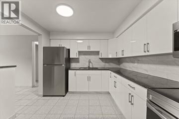 Windsor apartment for rent - A kitchen with white cabinets and a black counter top.
