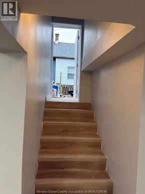Windsor apartment for rent - A staircase with a wooden handrail leads to a doorway.