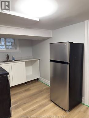 Windsor apartment for rent - A kitchen with a black fridge and white cabinets.