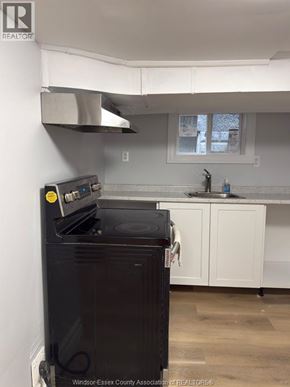 Windsor apartment for rent - A black oven in a kitchen with white cabinets.