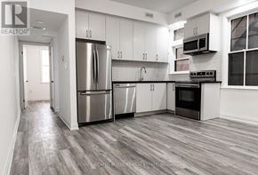 Toronto (Moss Park) multi-family for rent - A modern kitchen with stainless steel appliances and white cabinets.