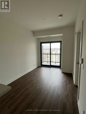 Clarington (Bowmanville) condo for rent - A room with wooden floors and a large window.