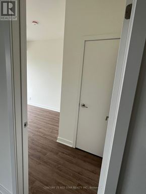 Clarington (Bowmanville) condo for rent - A white door is in a room with wood flooring.