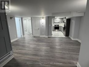 Oshawa (Eastdale) apartment for rent - A spacious room with a kitchen area in the background.