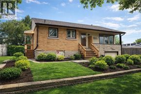 Kitchener apartment for rent - A house with a brown brick exterior and a wooden front porch.
