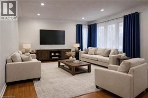 Kitchener apartment for rent - A living room with a large couch, a coffee table, and a flat screen TV mounted on the wall.