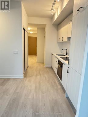 Toronto (Banbury-Don Mills) condo for rent - A kitchen with white cabinets and a wooden floor.