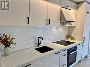 Toronto (Banbury-Don Mills) condo for rent - A kitchen with white cabinets and a wooden floor.