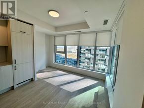 Toronto (Banbury-Don Mills) condo for rent - A kitchen with white cabinets and a view of a cityscape through the windows.