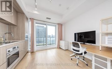 Toronto (Regent Park) condo for rent - A modern kitchen with a white chair and a flat screen TV.