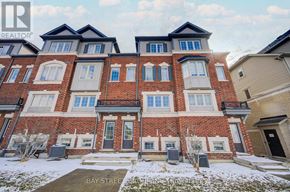Oshawa (Windfields) townhouse for rent - A large red brick building with a bay window in front.