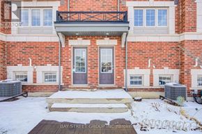 Oshawa (Windfields) townhouse for rent - A red brick house with a black railing on the balcony.