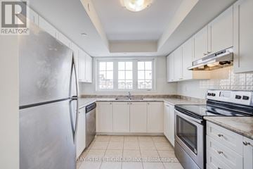 Oshawa (Windfields) townhouse for rent - A kitchen with white cabinets and a stainless steel refrigerator.