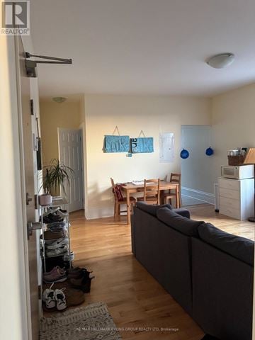 Ottawa multi-family for rent - A living room with a grey couch and a dining table.