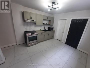 Windsor apartment for rent - A kitchen with a stove top oven, microwave, and a refrigerator.