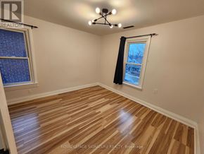 Windsor apartment for rent - A room with wooden flooring and a window with a view of a house.