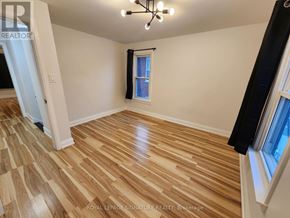 Windsor apartment for rent - A room with wooden flooring and a window with a black curtain.